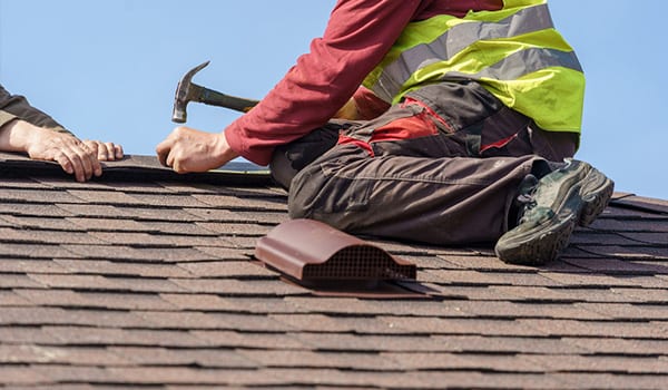 Two-roofers-nailing-shingles-to-a-roof